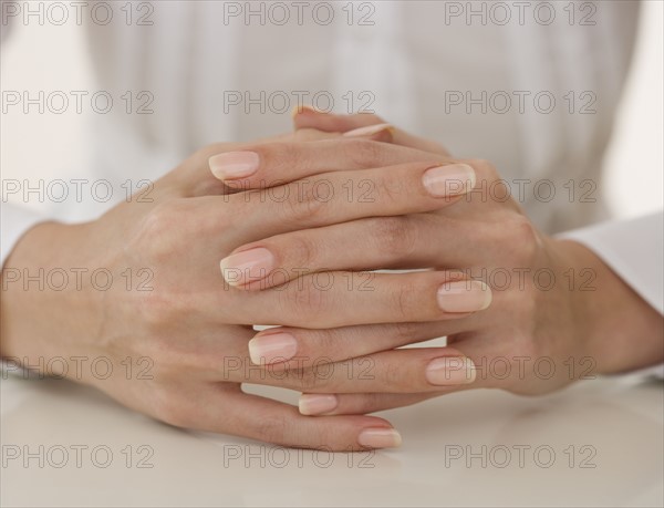 Close up of woman’s hands clasped.