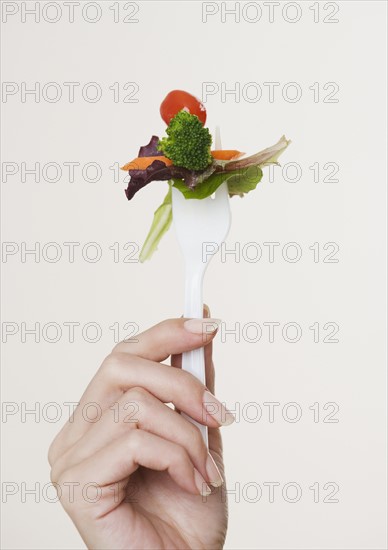 Close up of salad on fork.