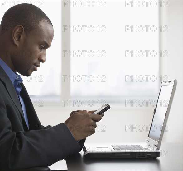 Businessman dialing cell phone.