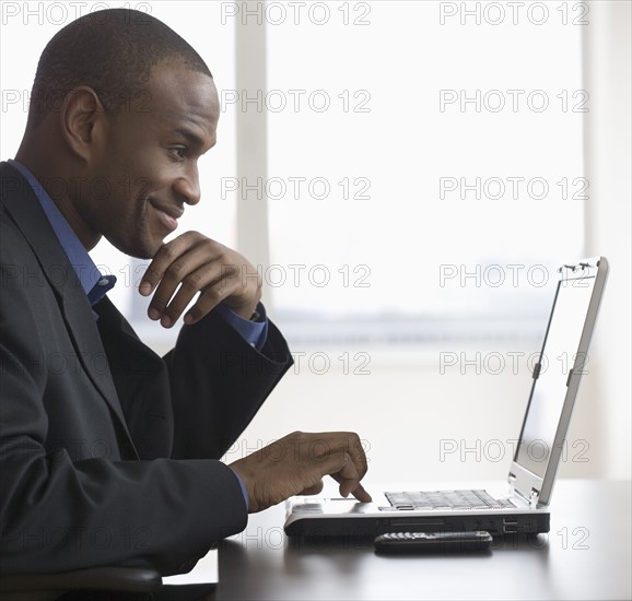 Businessman typing on laptop.