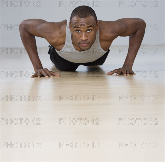 Man doing pushups indoors.