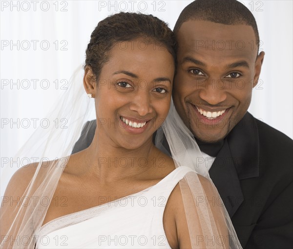 Portrait of bride and groom hugging.