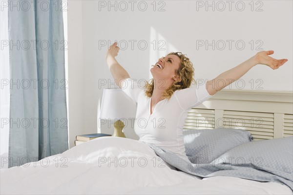 Woman stretching in bed.