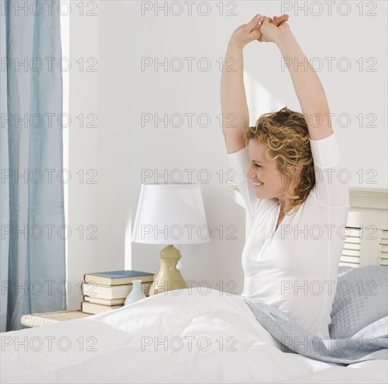 Woman stretching in bed.