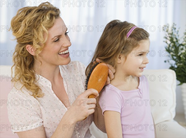 Mother brushing daughter’s hair.