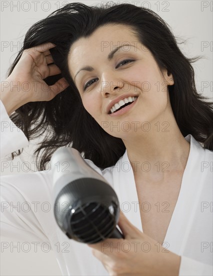 Woman blow drying hair.