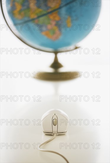 Computer mouse in front of globe.