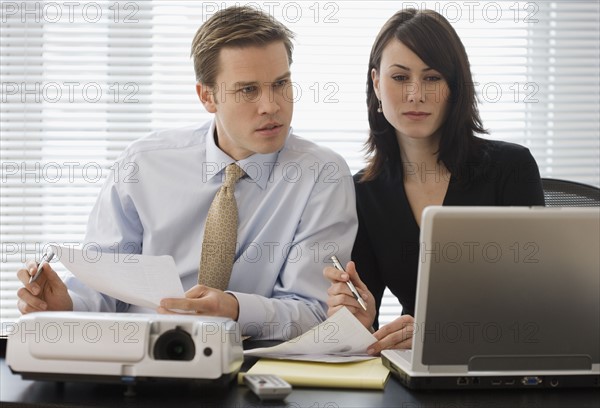 Businesspeople looking at laptop.