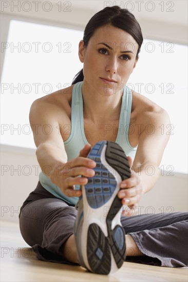 Woman stretching on floor.