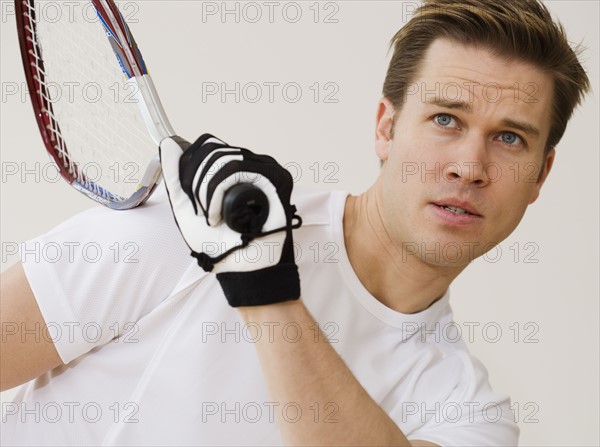 Close up of man playing racquetball.