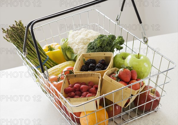 Assorted fruits and vegetables in shopping basket.