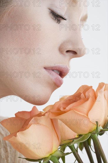 Close up of woman smelling flowers.