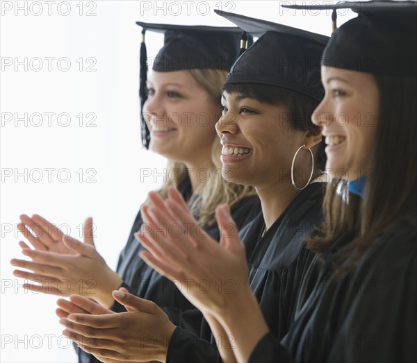 Multi-ethnic women wearing graduation cap and gown.