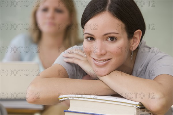 Woman with chin on hand in classroom.