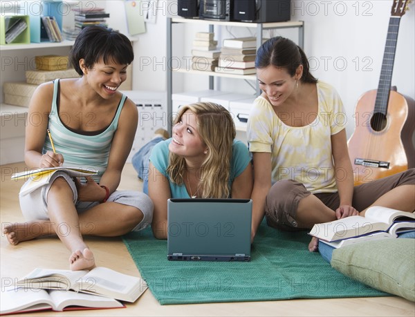 Multi-ethnic women studying on floor.