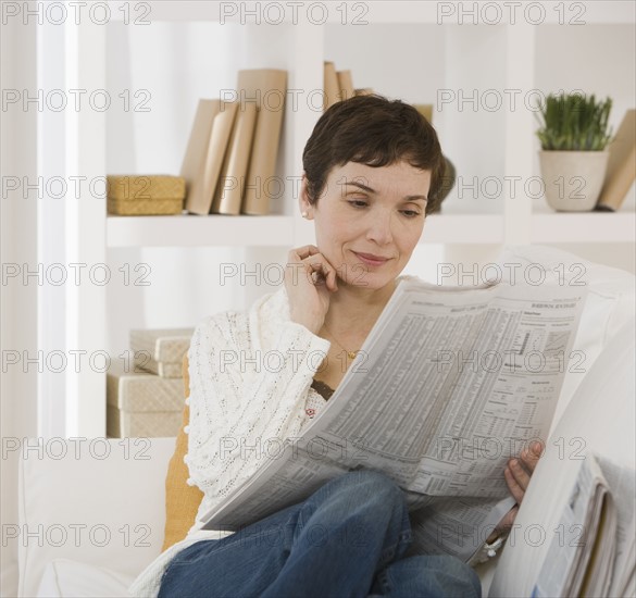 Woman reading newspaper.