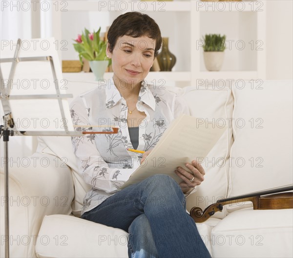 Woman reading violin sheet music.