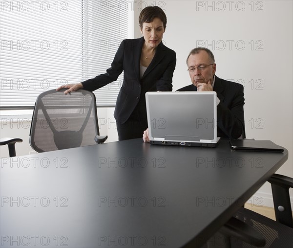 Businesspeople looking at laptop.