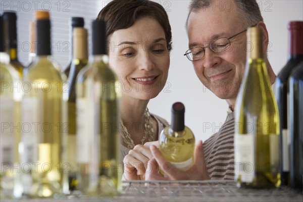 Couple looking at wine in store.