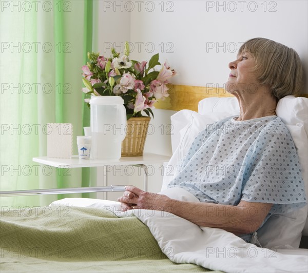 Senior woman laying in hospital bed.