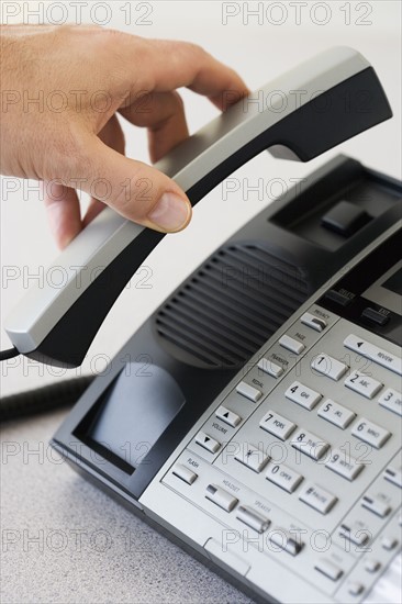 Man picking up telephone receiver.