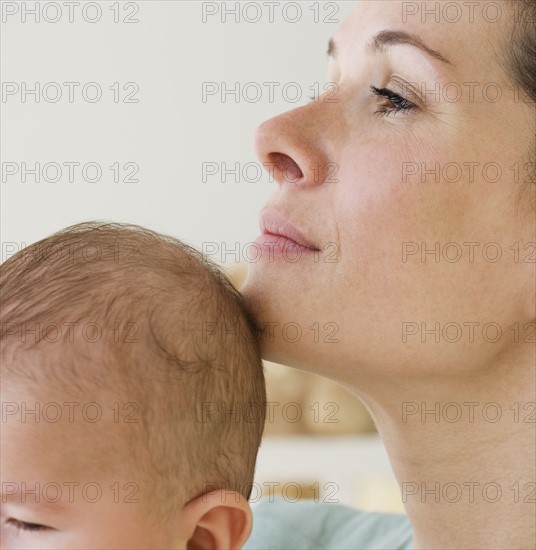 Mother resting chin on baby’s head.