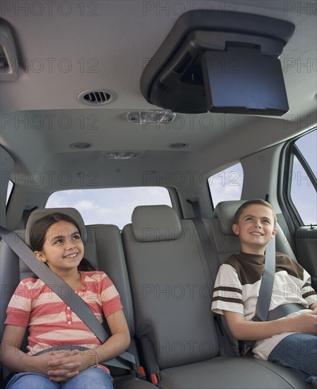 Brother and sister watching moving in car.