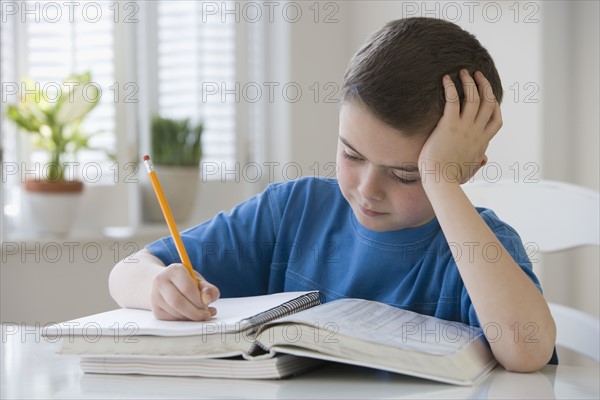 Boy doing homework at table.