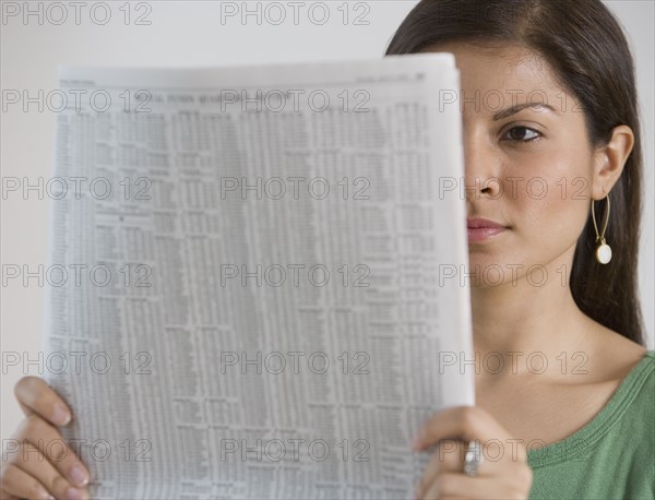 Indian woman reading newspaper.