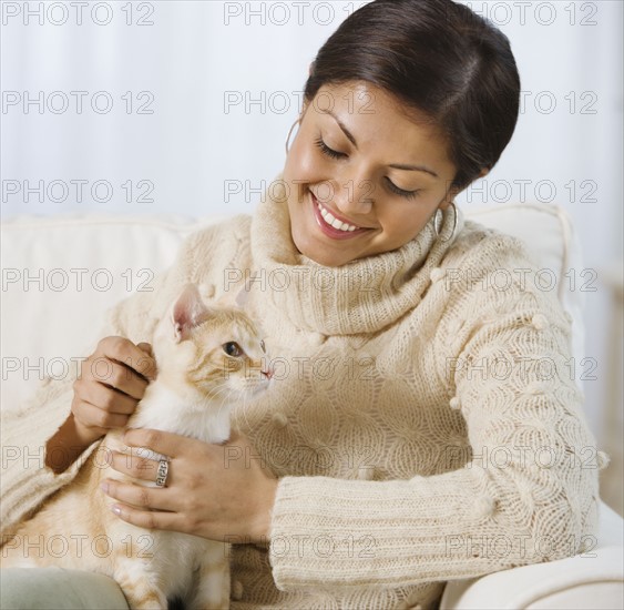 Indian woman petting cat.