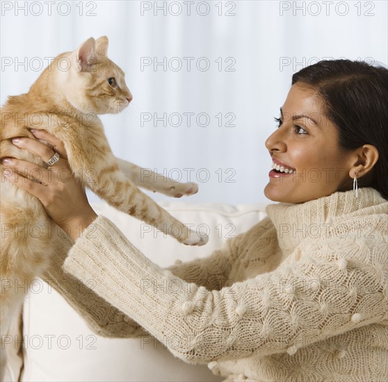 Indian woman holding cat.