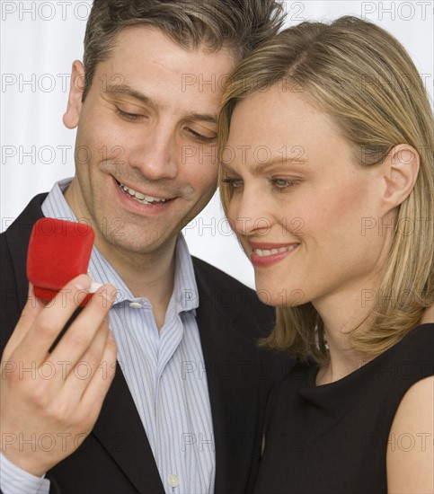 Couple looking at ring box.