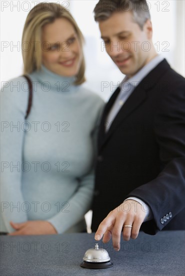 Couple ringing bell at counter.