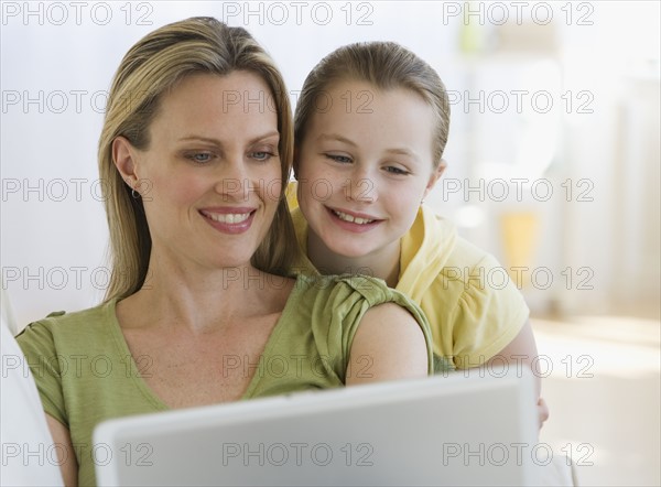 Mother and daughter looking at laptop.