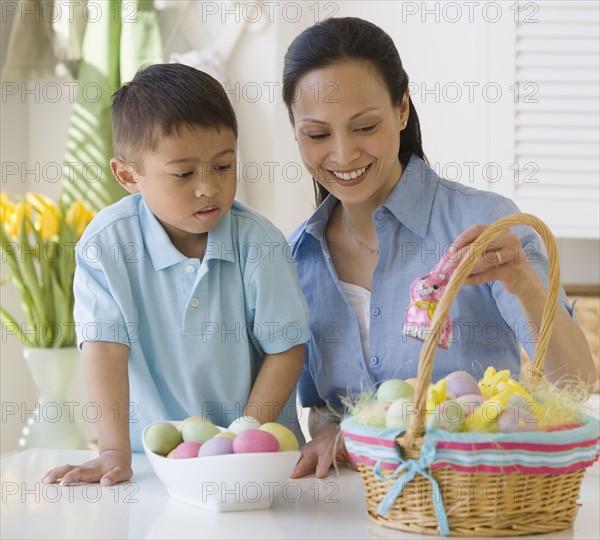 Asian mother and son making Easter basket.