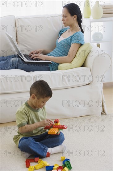 Asian mother and son relaxing in livingroom.