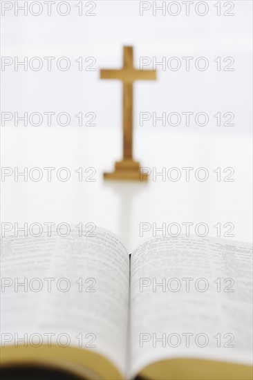 Open book and cross in background.