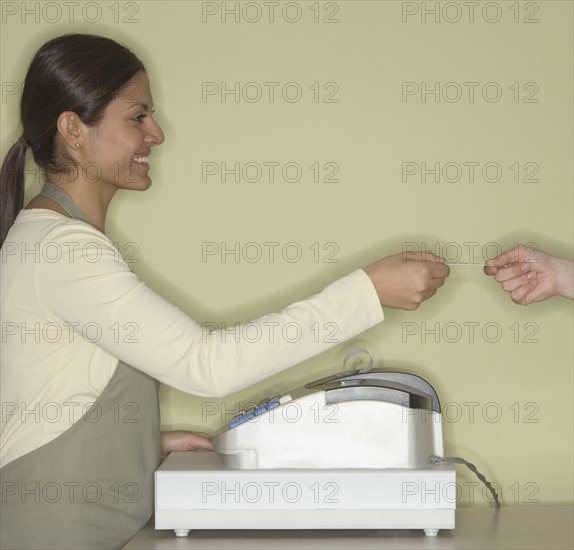 Indian female clerk accepting credit card.