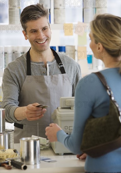 Woman paying at paint store.