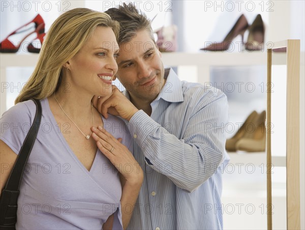 Couple looking at necklace in boutique.