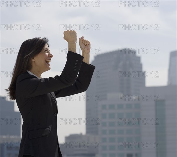 Businesswoman cheering in urban scene.