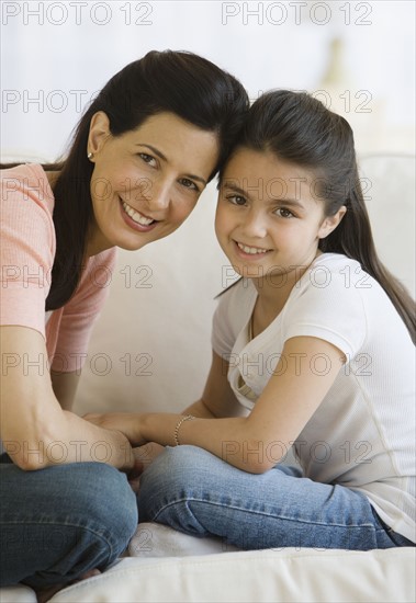 Mother and daughter touching heads.