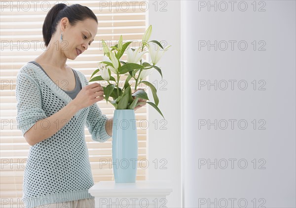 Asian woman arranging flowers.