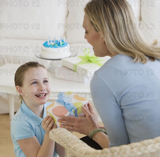 Mother giving daughter birthday gift.