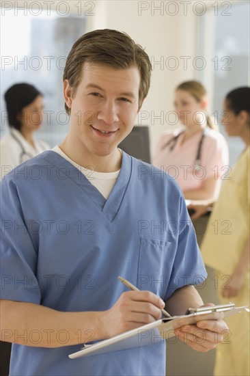 Portrait of male doctor writing on chart.
