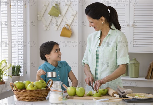 Mother and daughter making apple pie.