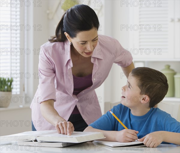 Mother helping son with homework.