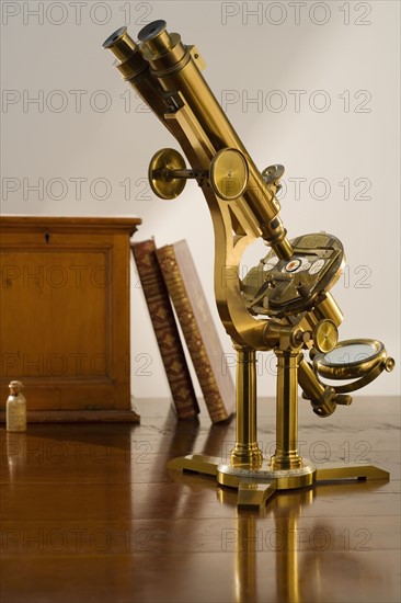 Old fashioned microscope on table.