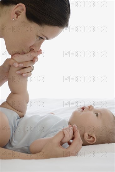 Mother kissing baby’s foot.