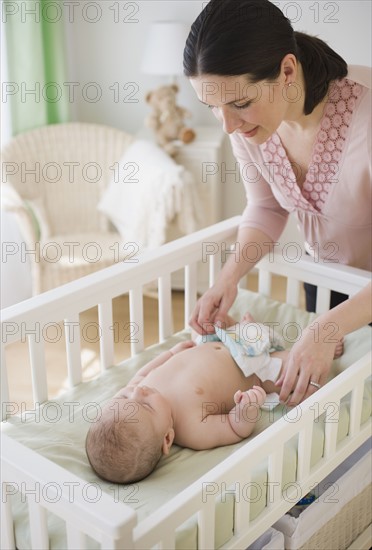 Mother changing baby’s diaper.